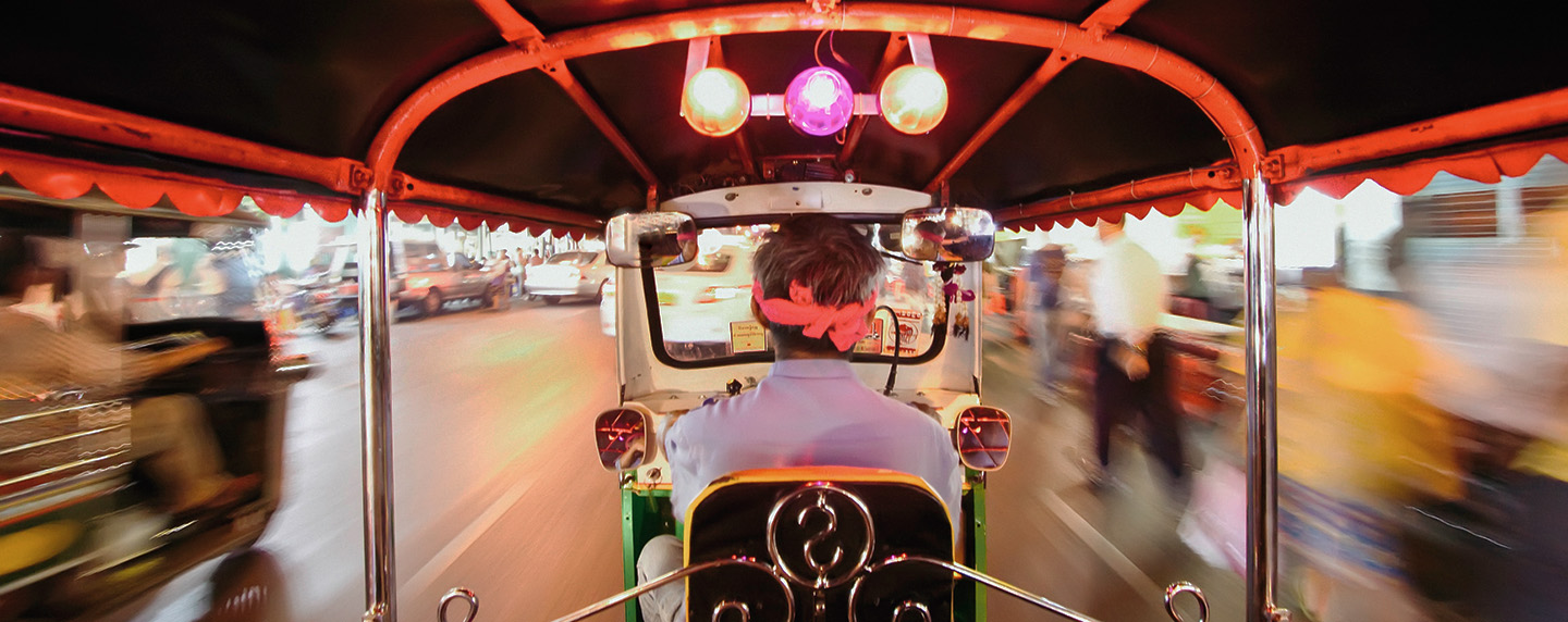 Tuk Tuk or auto rickshaw in motion at night, Bangkok, Thailand,